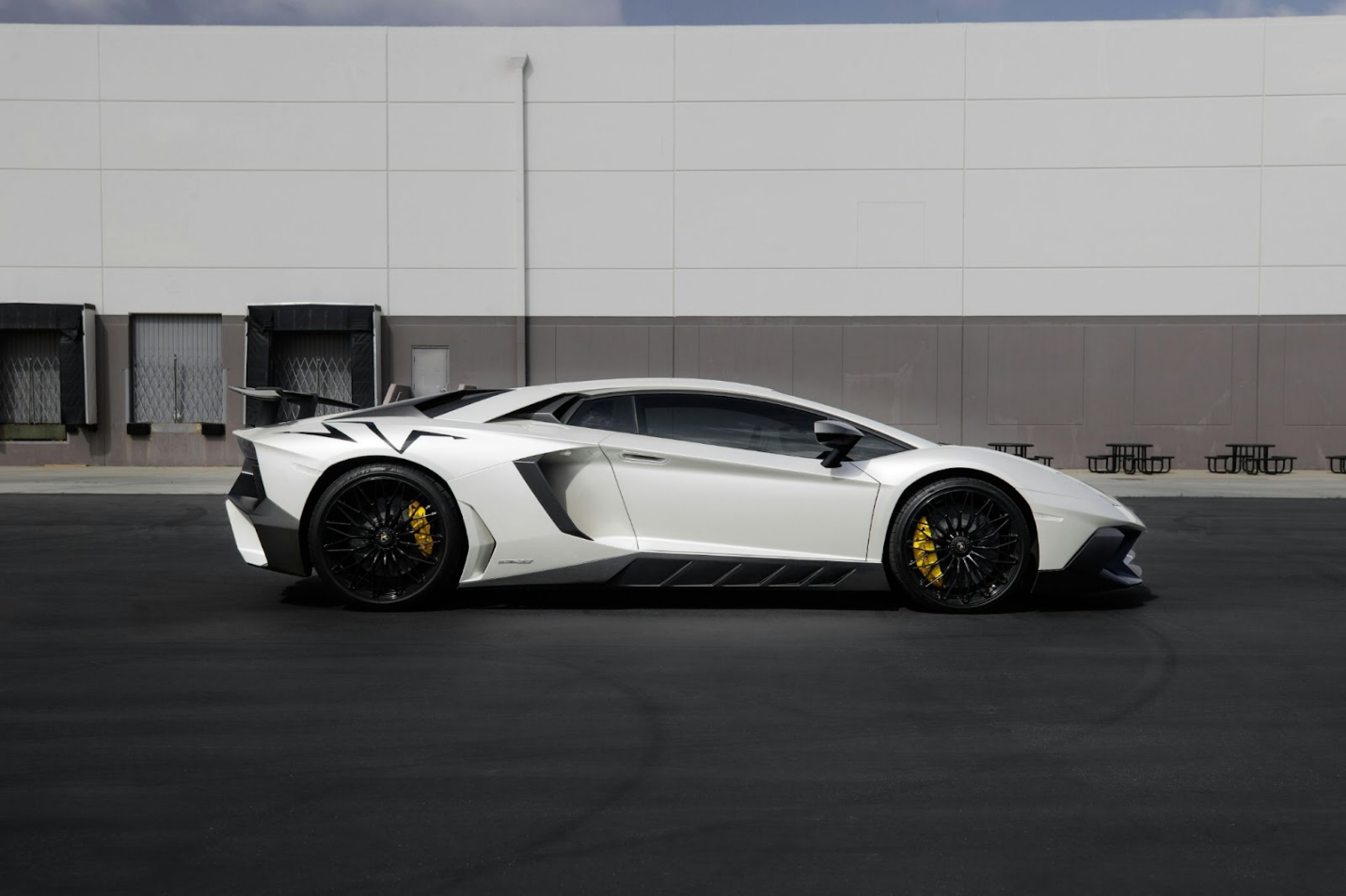 a white lamborghini huracan on the road for an hourly rental 